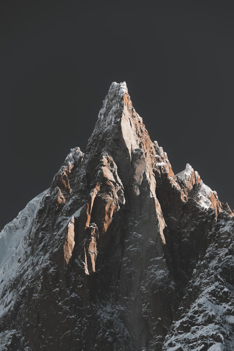 A snow covered mountain with a dark sky in the background