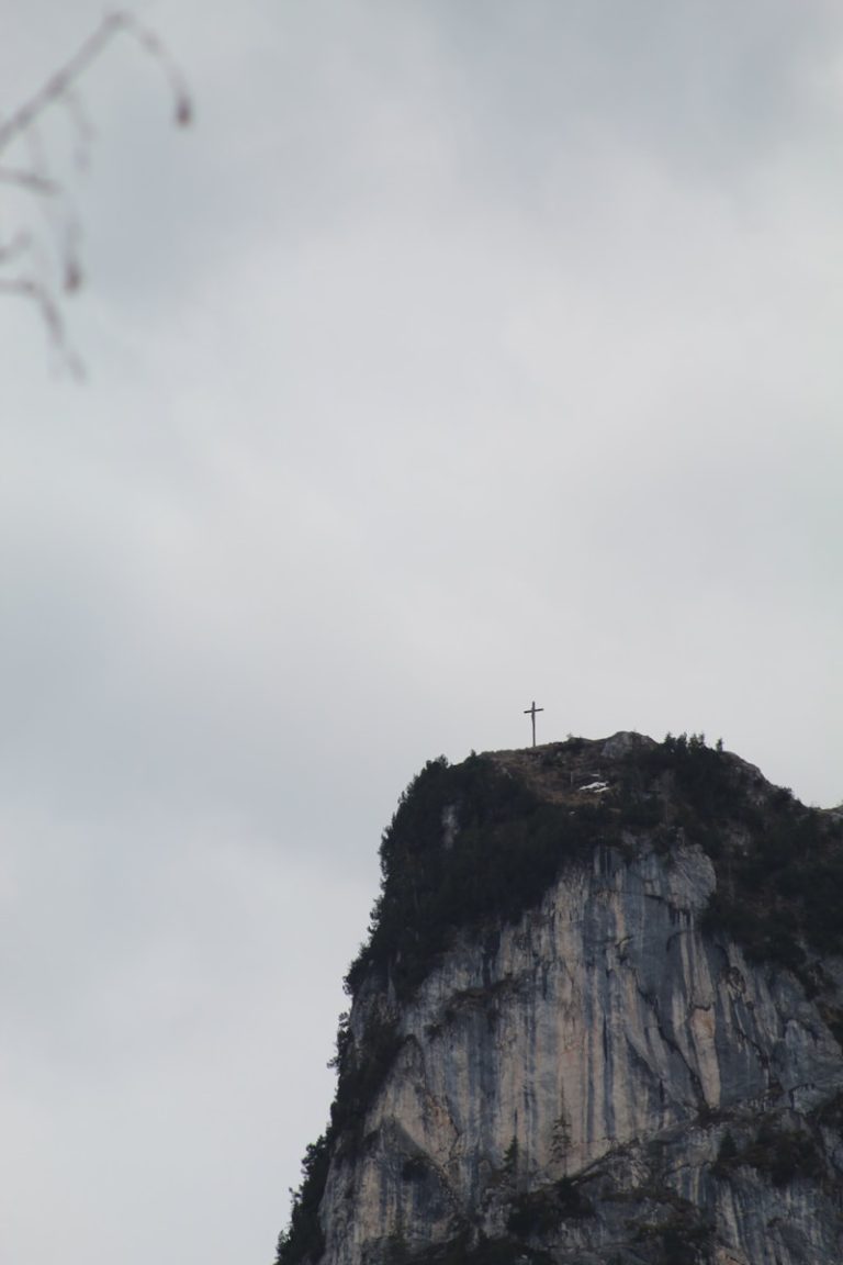 a cross on top of a mountain on a cloudy day