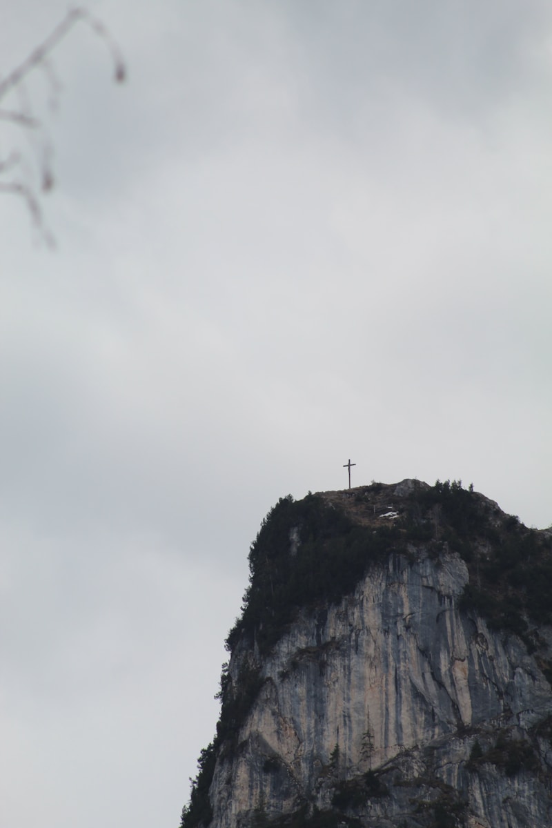 a cross on top of a mountain on a cloudy day